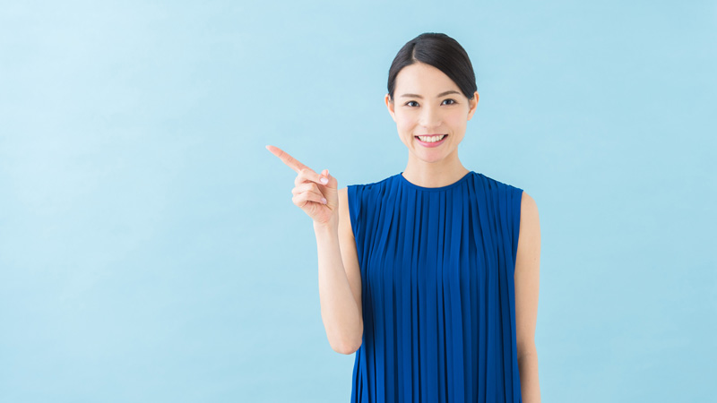 人差し指を立てた笑顔の女性
