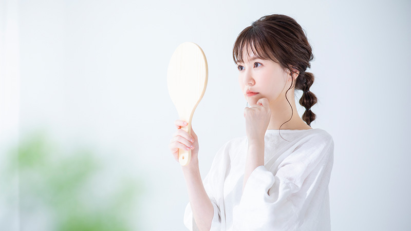 鏡を見ながら考える女性