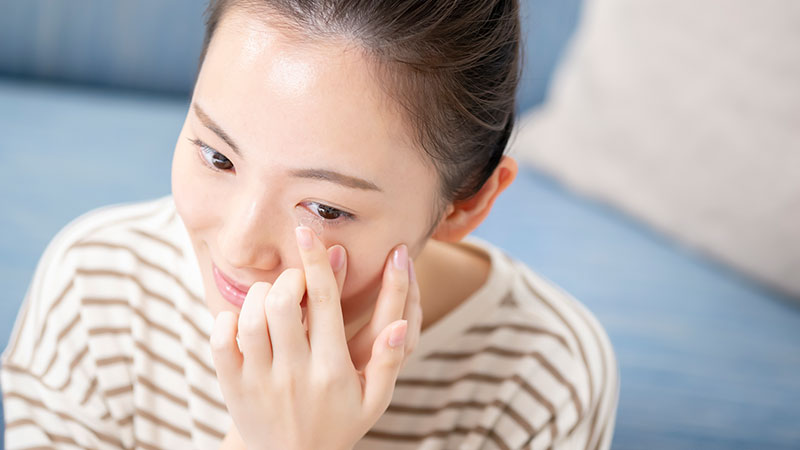 コンタクトレンズを目にのせる女性