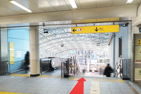 ②エスカレーター（階段）を下り、南口広場へ進みます。
